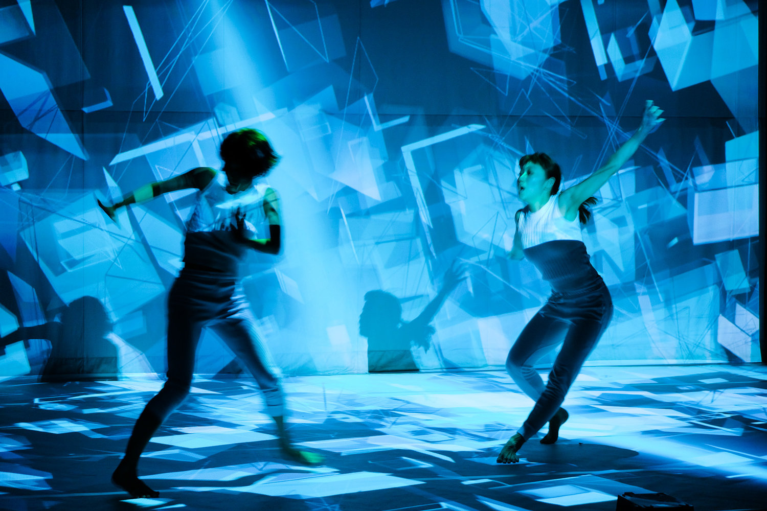 Two dancers in front of digital artwork © Studio Defasten