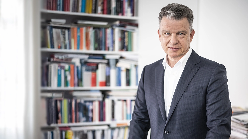 Paul-Bernhard Kallen in front of a bookshelf