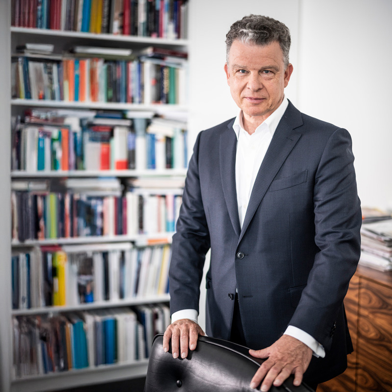 Paul-Bernhard Kallen in front of a bookshelf